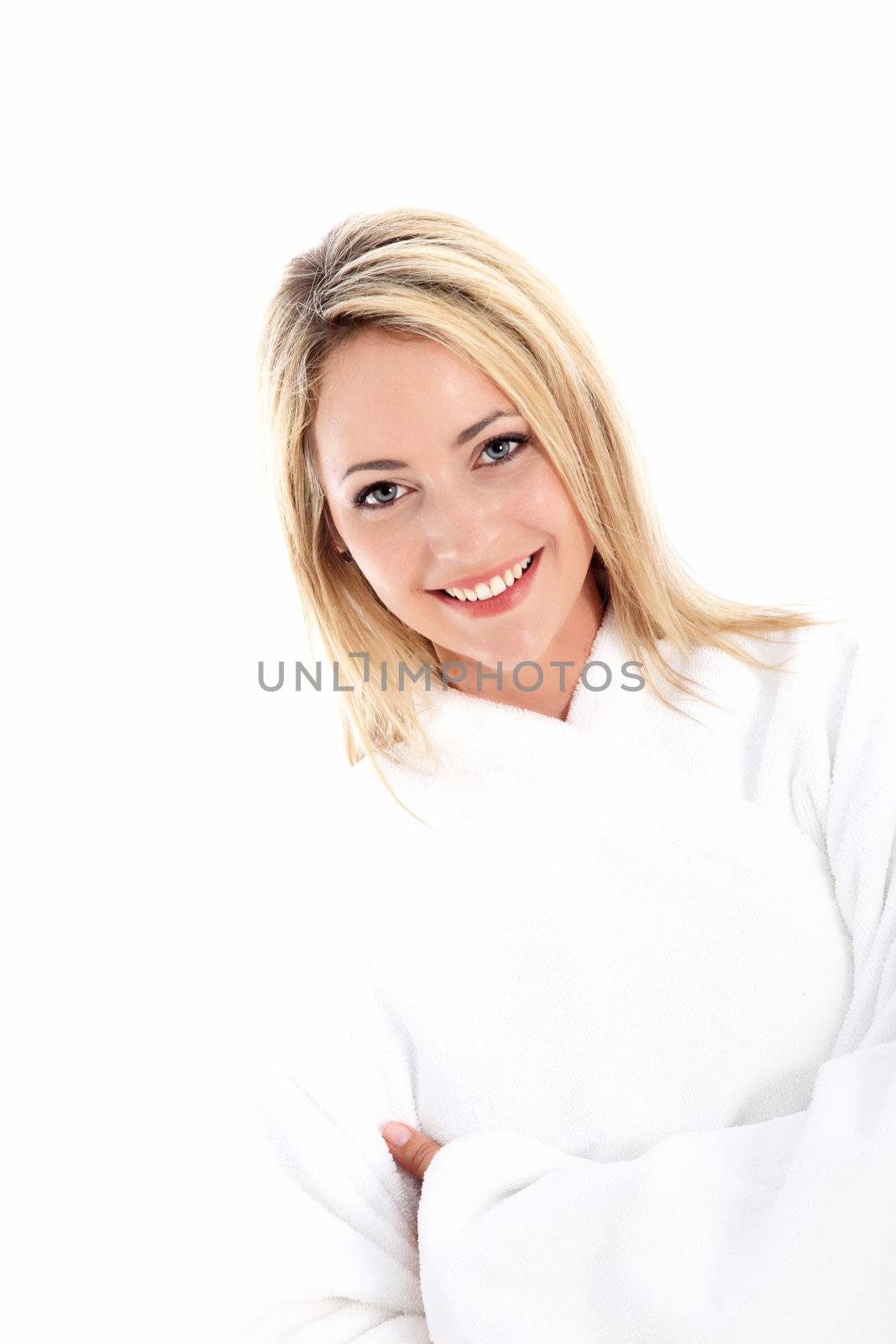 Happy healthy woman with a lovely radiant smile standing in a white bathrobe denoting purity and freshness 