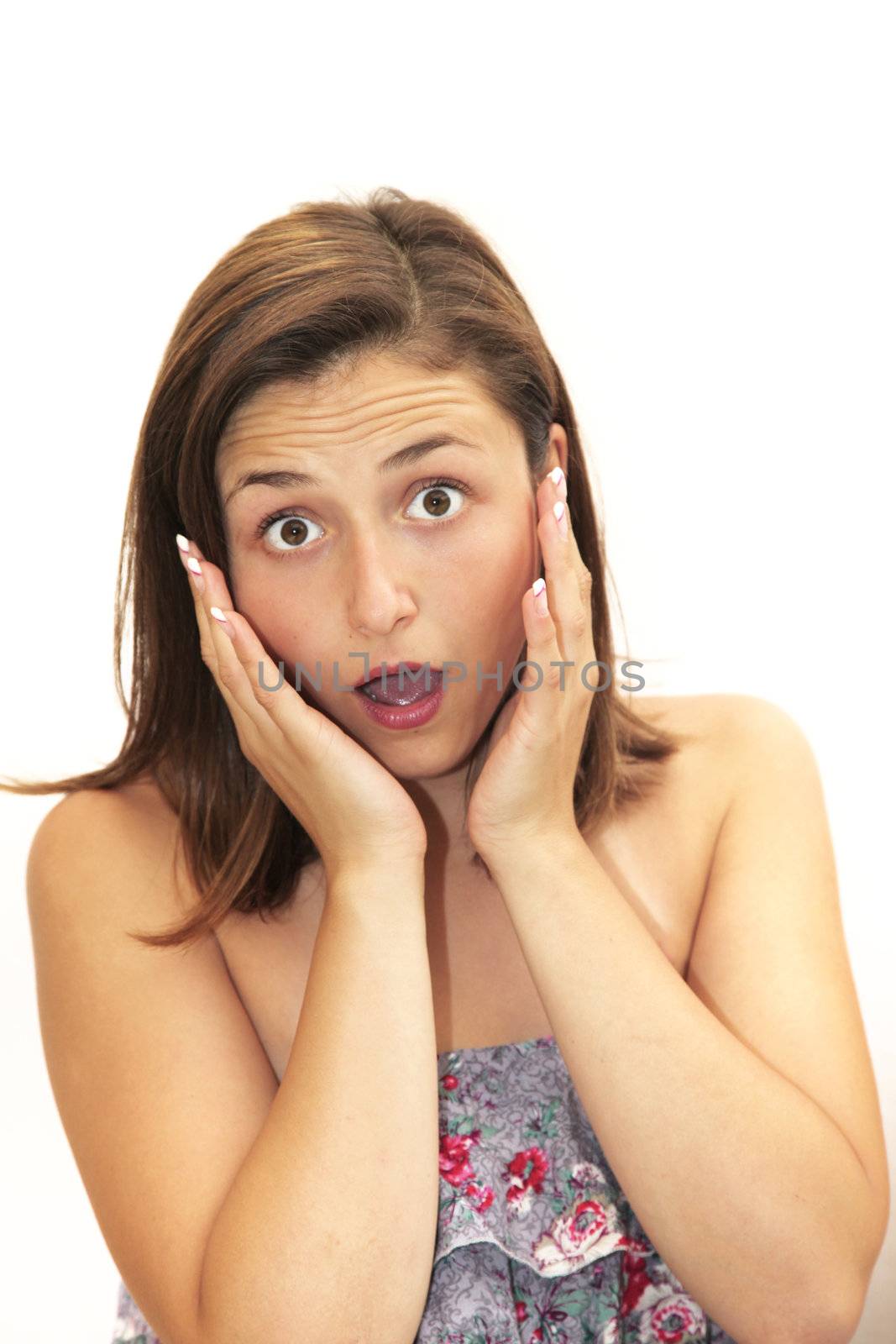 Woman reacting in amazement and surprise with wide eyes, her mouth open and her hands to her face 