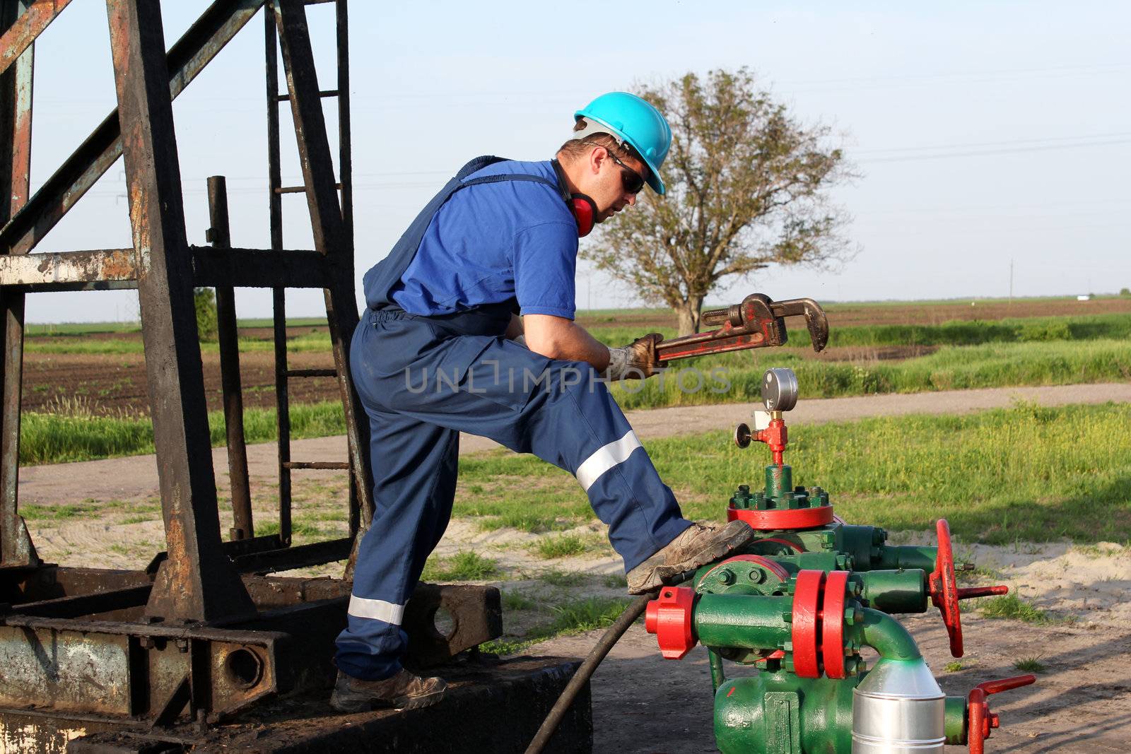 oil worker with wrench check pipeline by goce