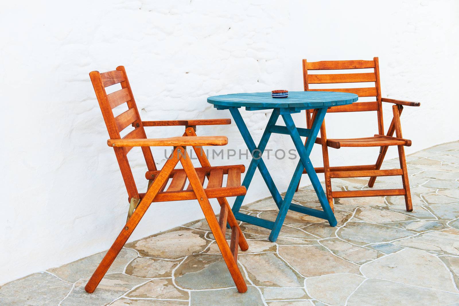 Colorful wooden chair and table arrangement from a Greek island alleyway