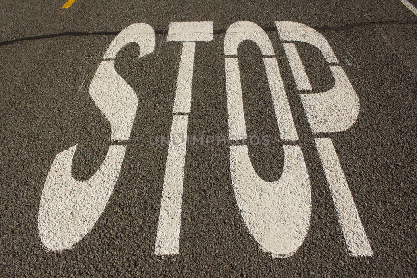 Stop letters in white paint on a road