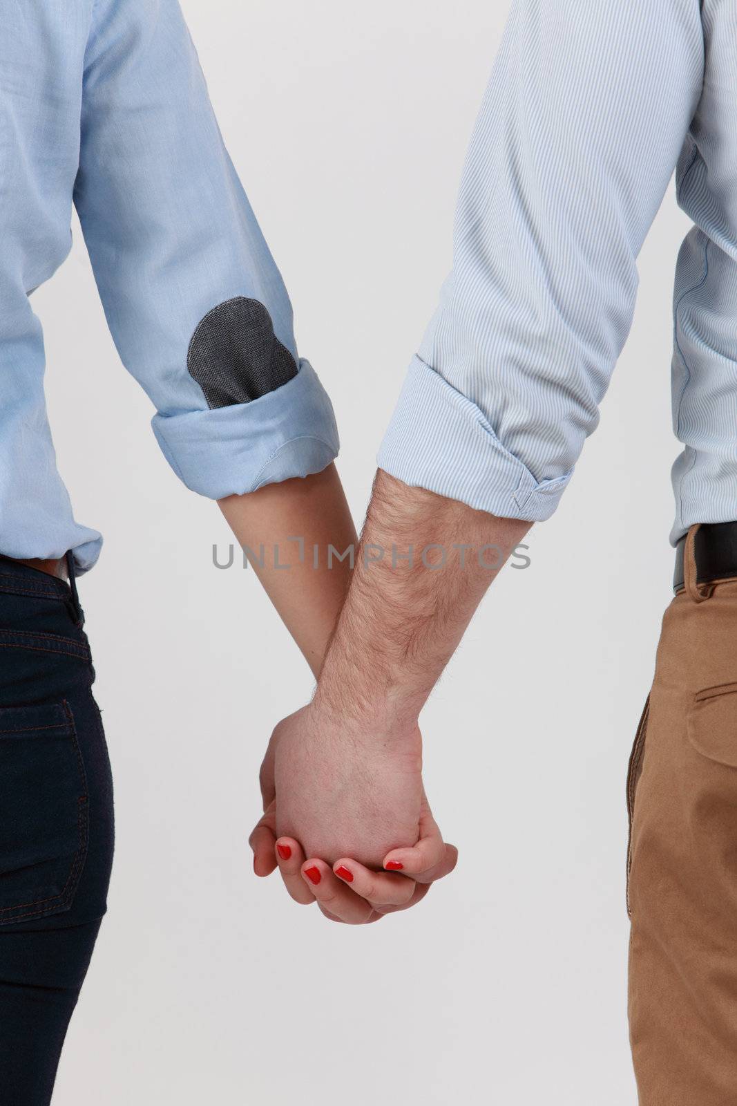 Mid section image of a couple holding hands against a white background.