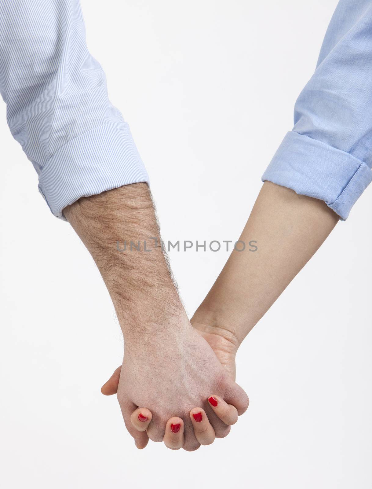 Close-up image of a couple holding hands with turned up sleeves.