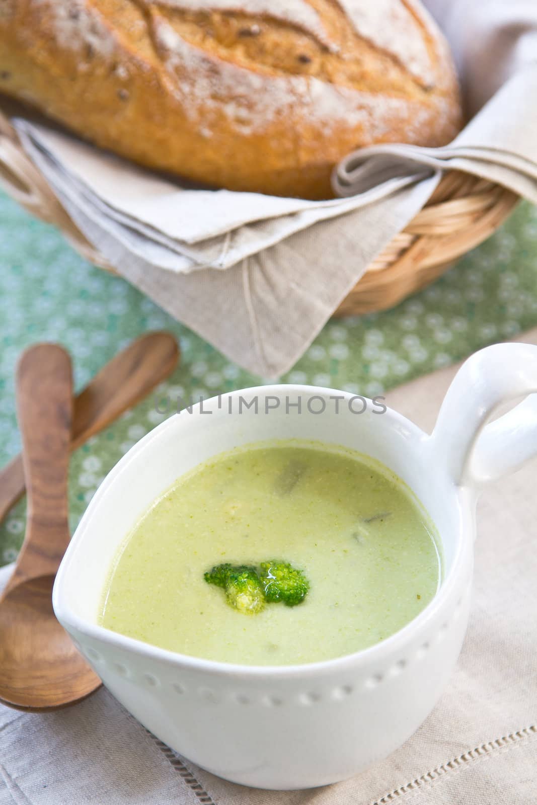 Broccoli soup by a loaf of wholemeal bread