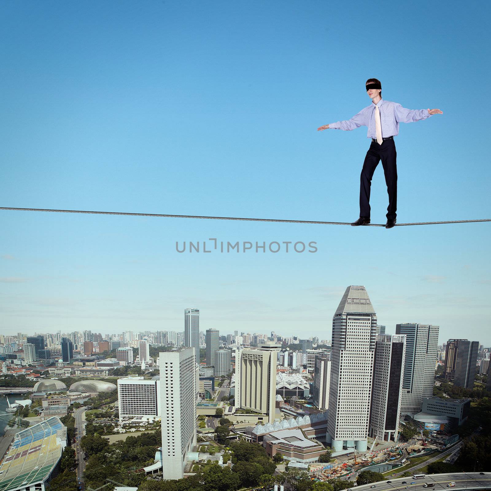 Business man balancing high over a cityscape