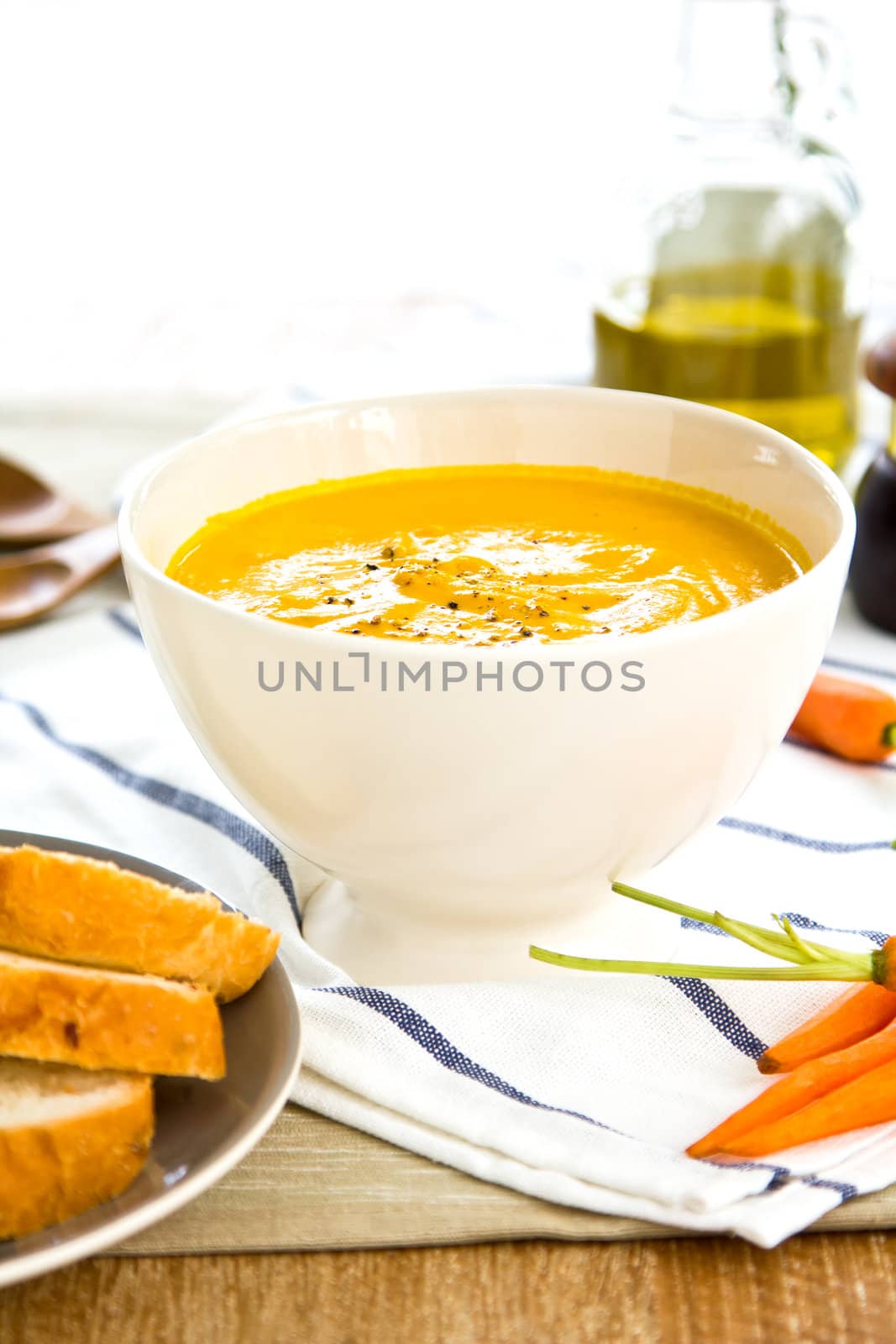 Carrot soup with some pieces of bread by baby carrot