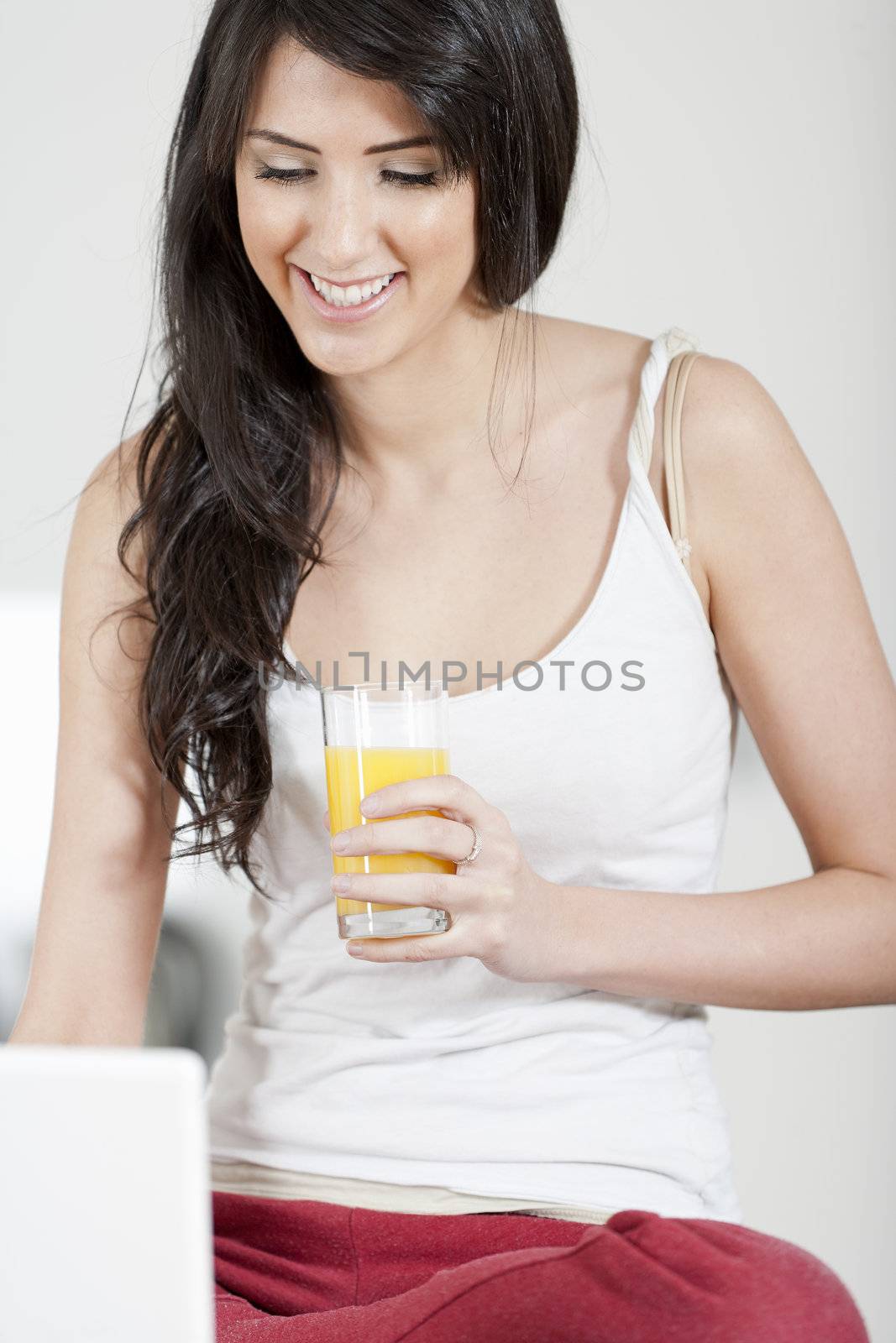 Young woman sat in kitchen on laptop