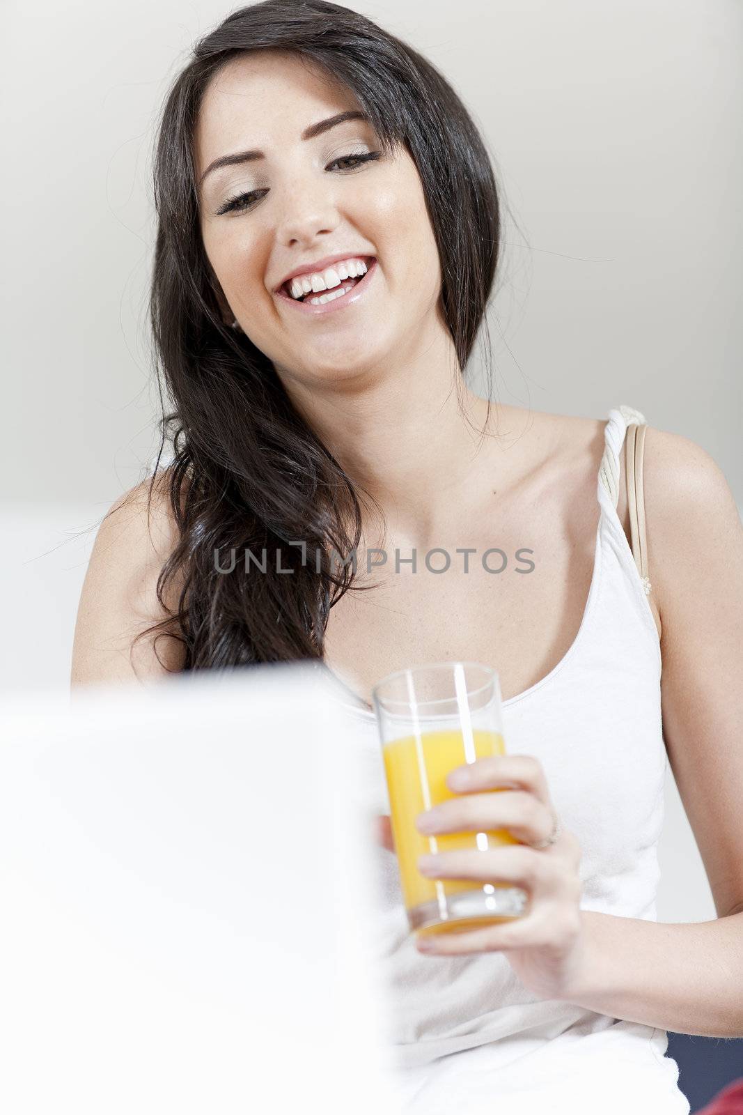 Young woman sat in kitchen on laptop