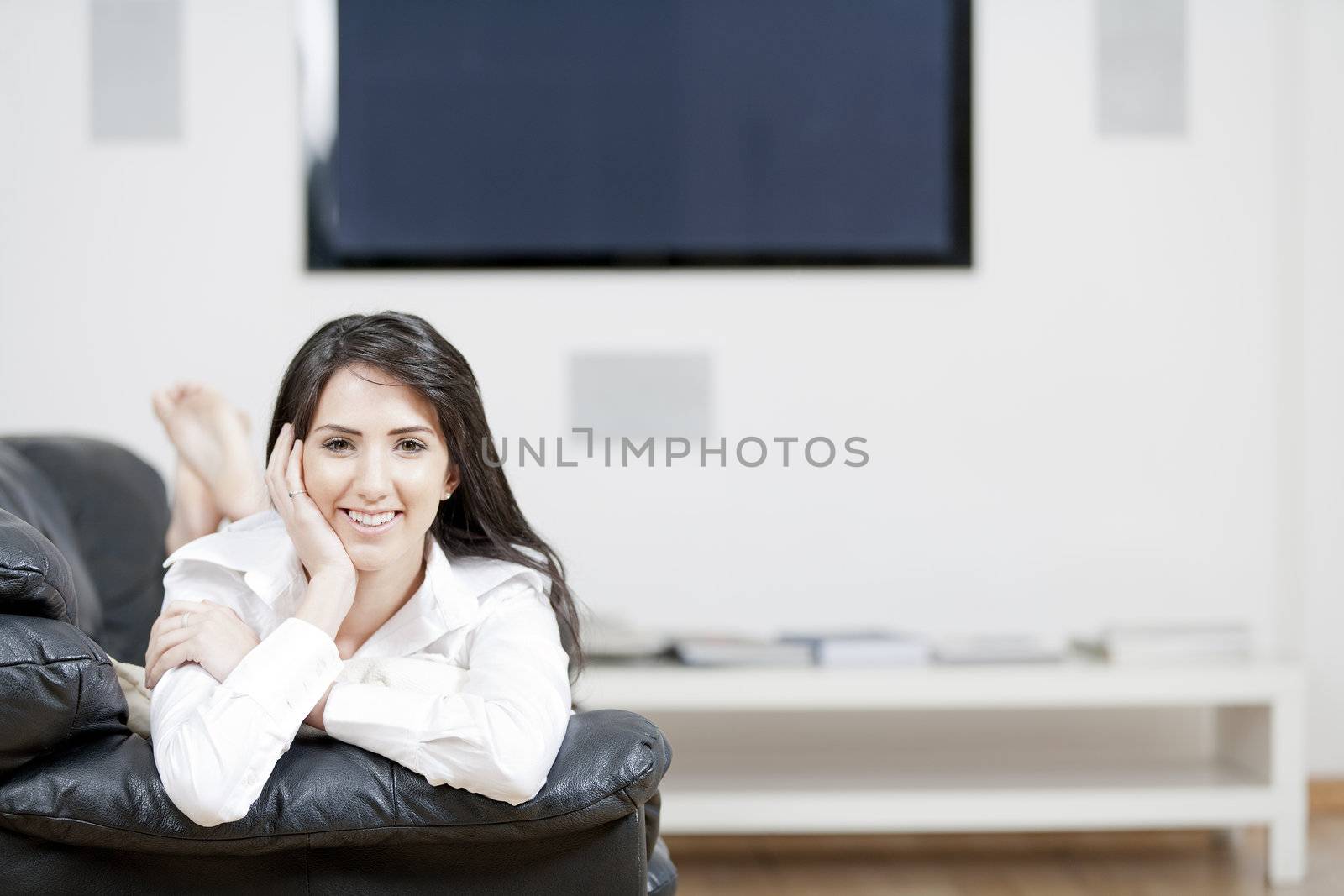 Young woman lying on sofa at home