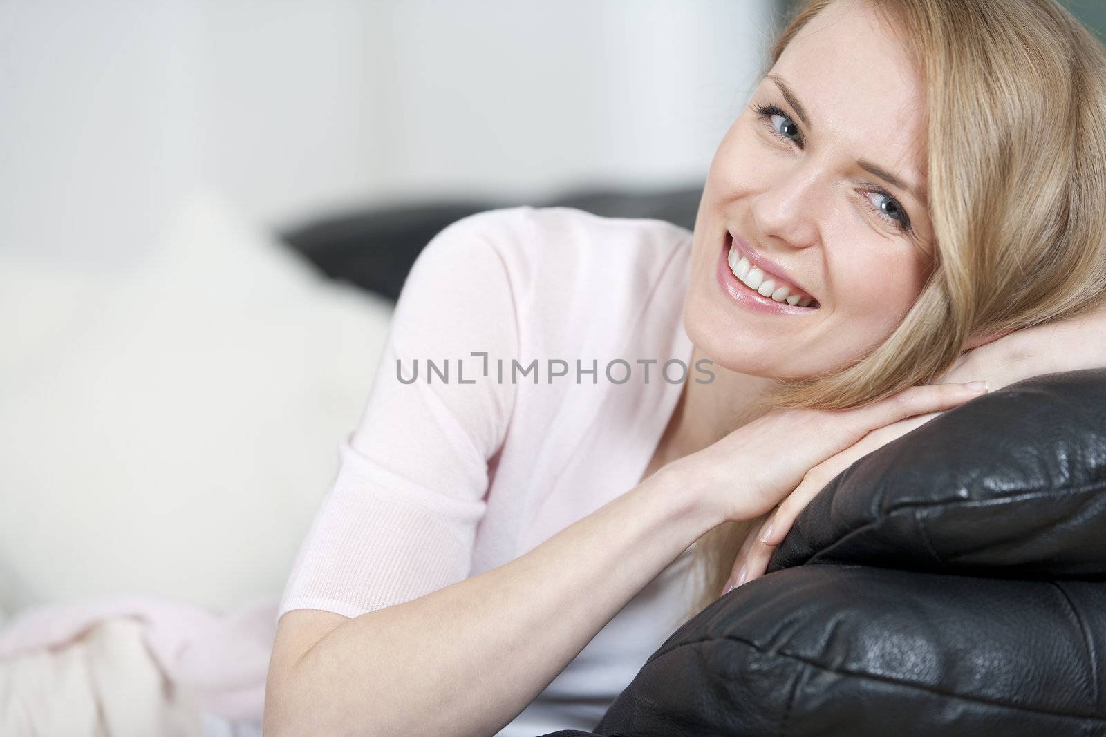 Young woman resting on sofa by studiofi