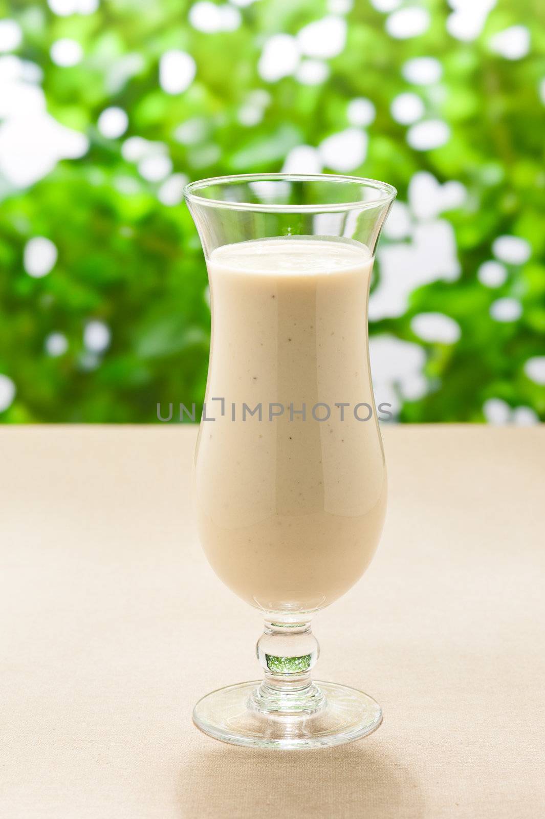 Banana milk shake with real fruit and a green background