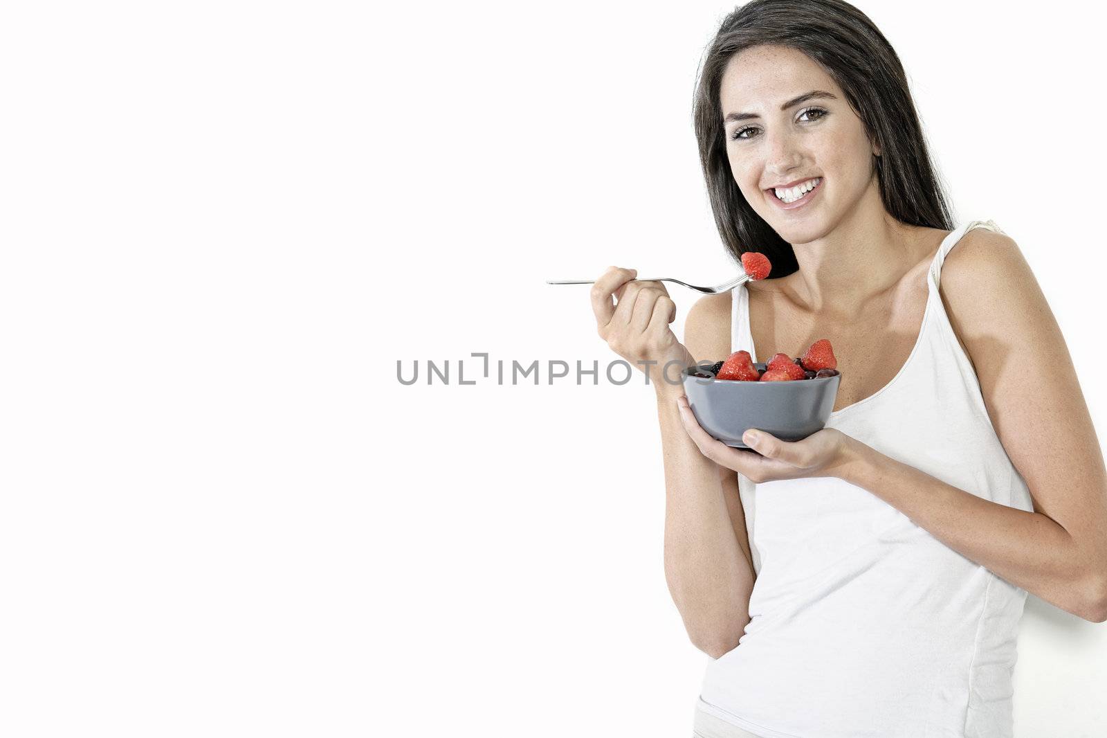 Beautiful young woman enjoying fresh fruit for breakfast at home