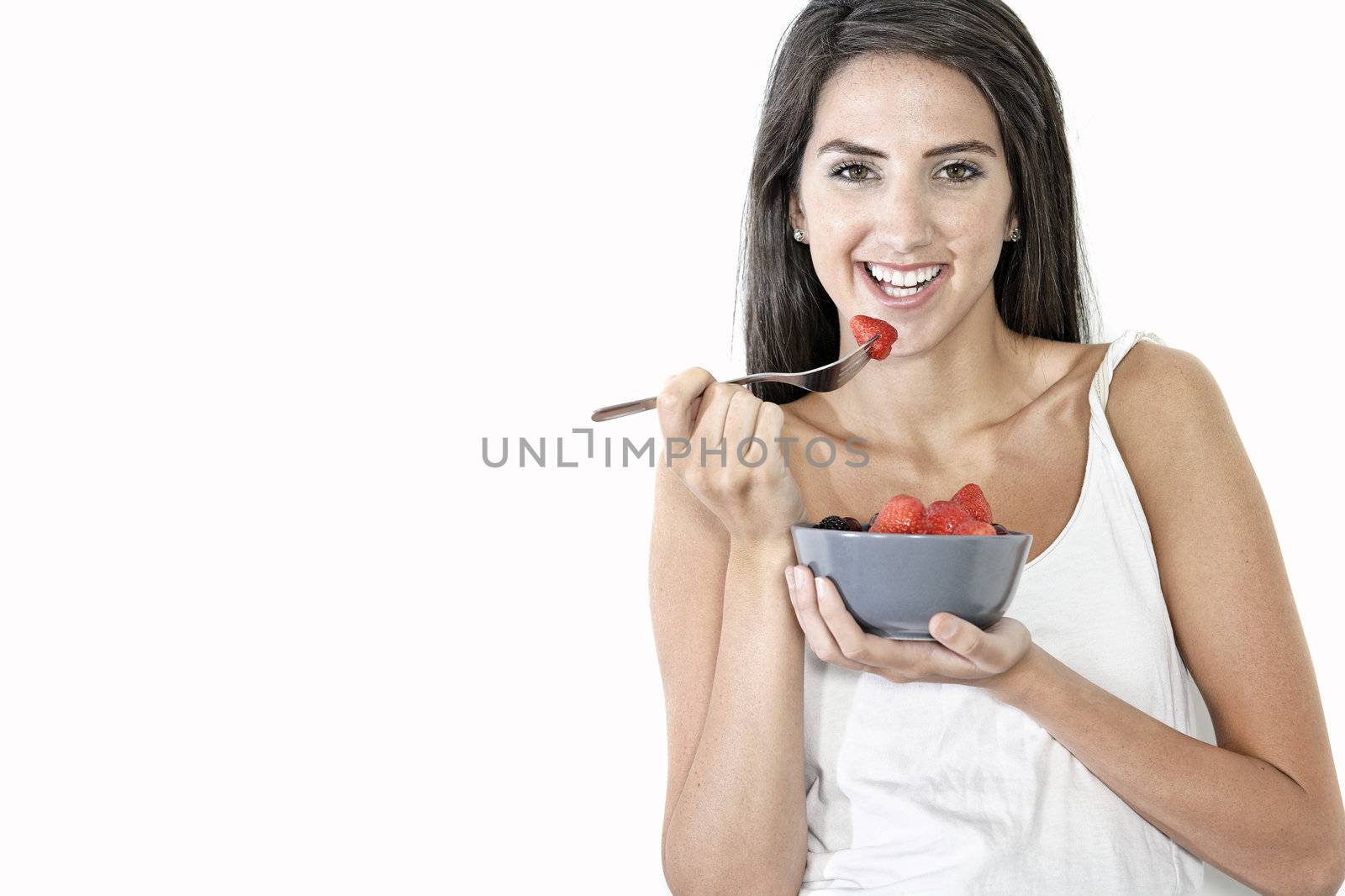 Beautiful young woman enjoying fresh fruit for breakfast at home