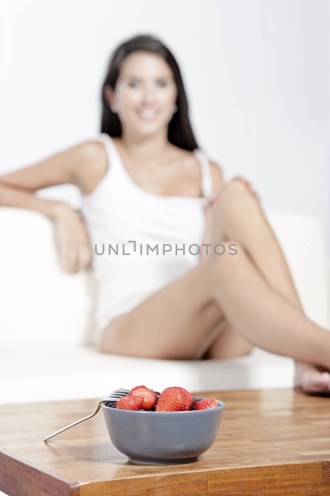 Beautiful young woman enjoying fresh fruit for breakfast at home