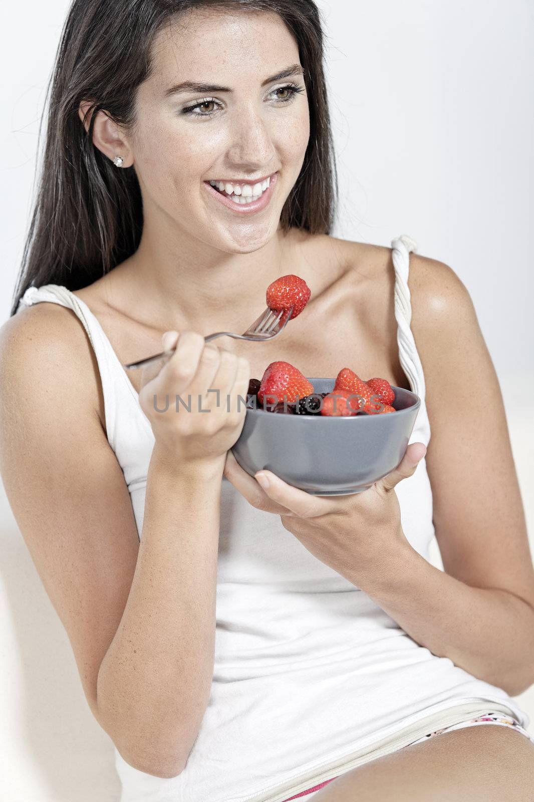 Woman eating breakfast at home by studiofi