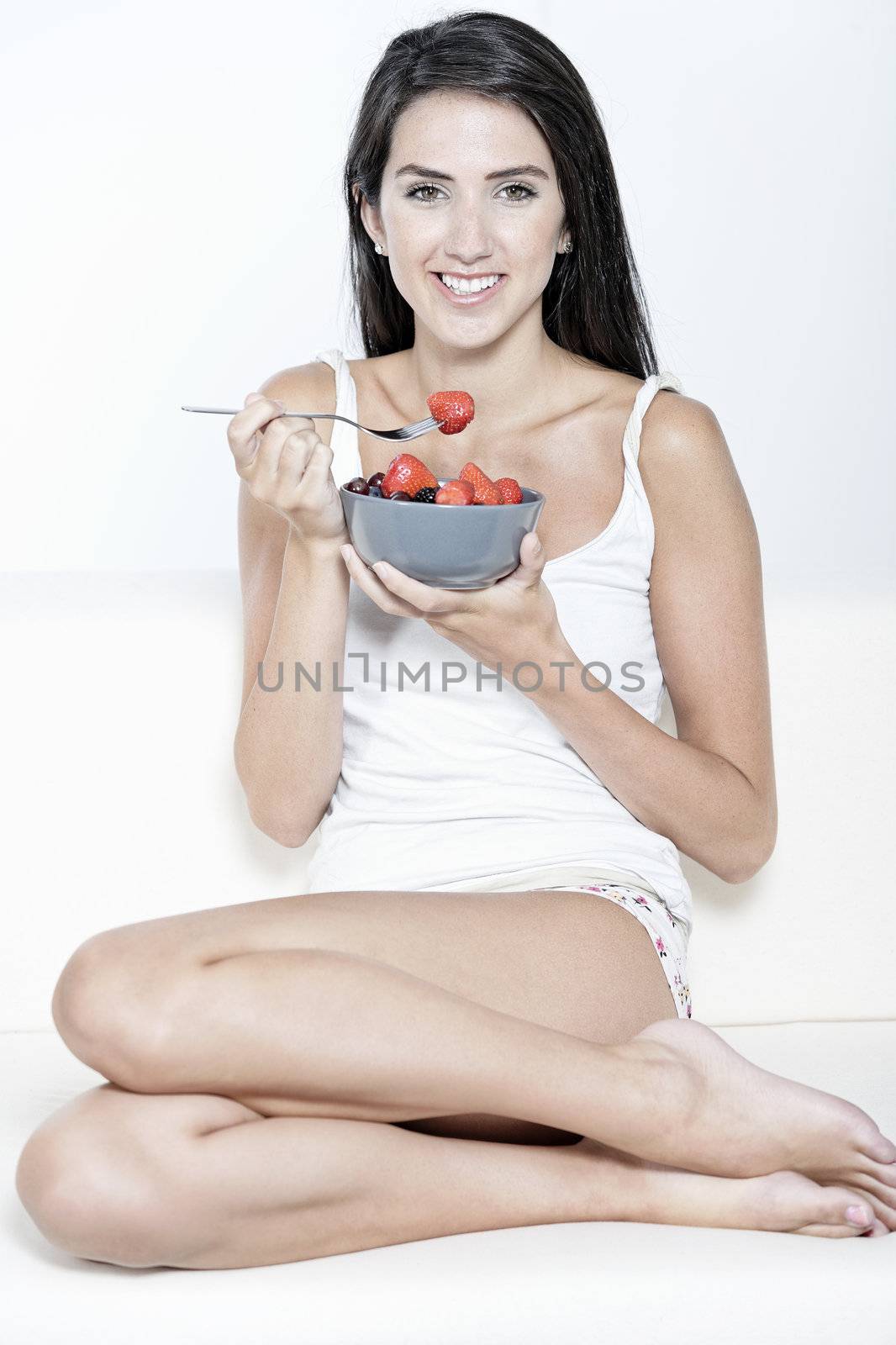 Woman eating breakfast at home by studiofi