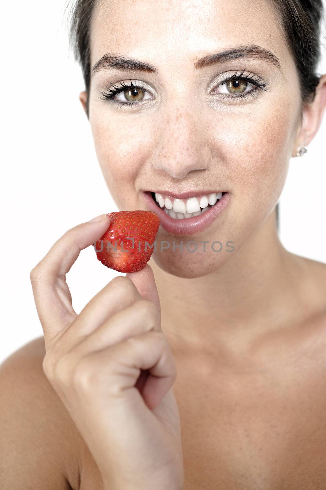 Beautiful young woman eating a fresh strawberry