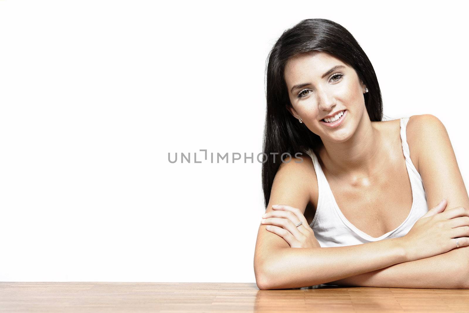 Beautiful young woman sitting next to a coffee table at home in casual clothes