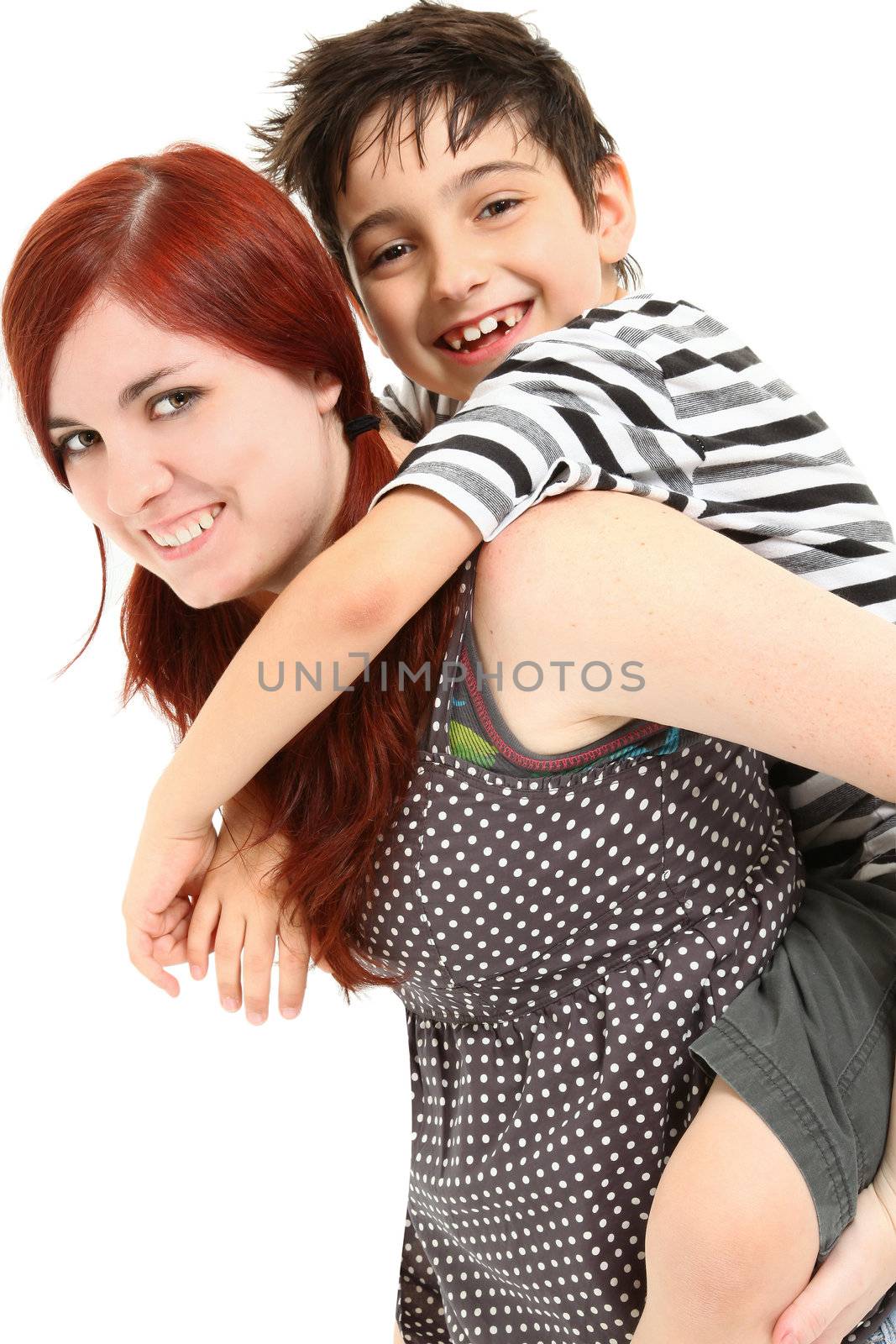 Adorable 8 year old boy getting piggy back ride from babysitter over white background.