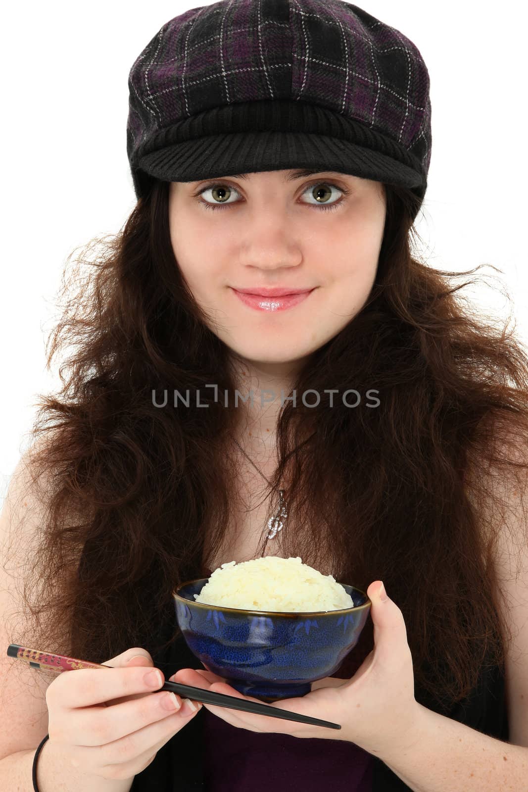 Attractive 18 year old young woman in hat eating bowl of rice with chopsticks over white.