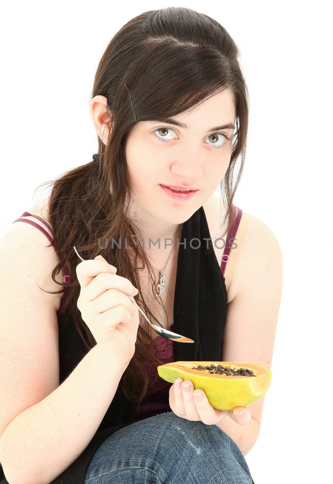 Attractive young woman eating a papaya fruit over white background.