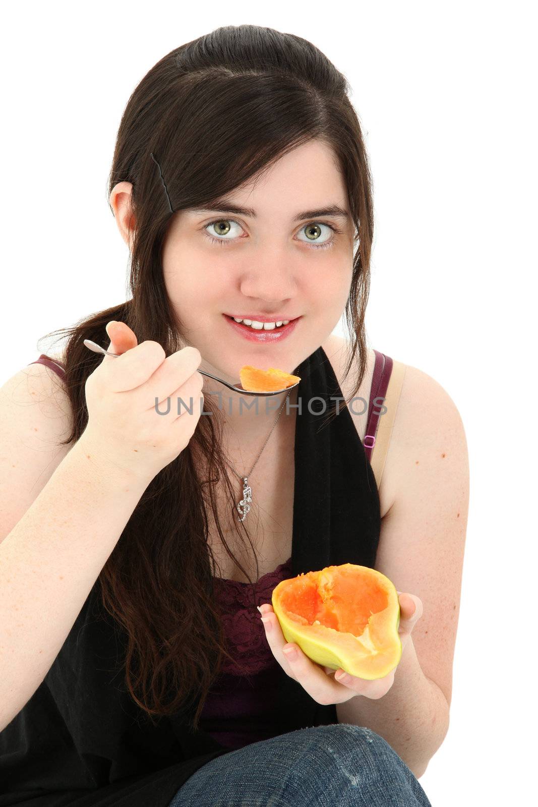 Attractive young woman eating a papaya fruit over white background.