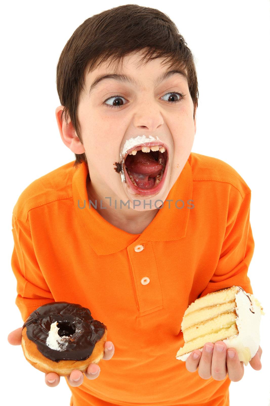 Attractive 8 year old boy with insane expression and hands full of sweets over white.