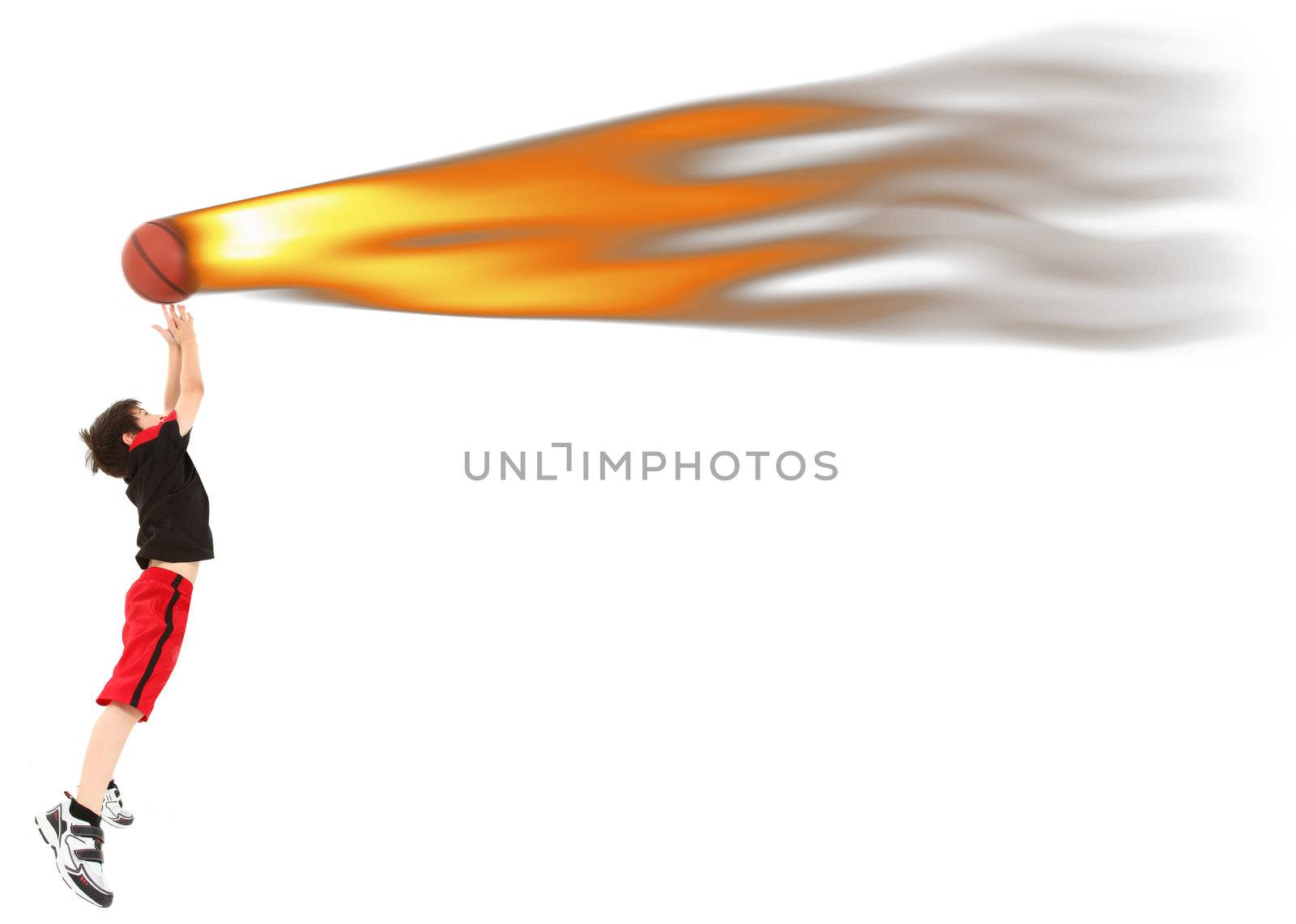 Energetic 8 year old boy child in basketball uniform jumping to catch bal on fire.