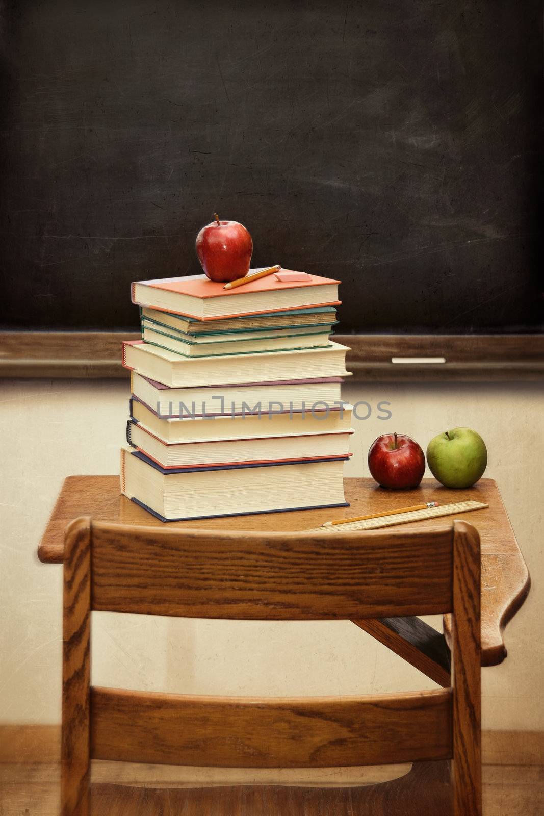 Old desk with a stack of books and apple with vintage look