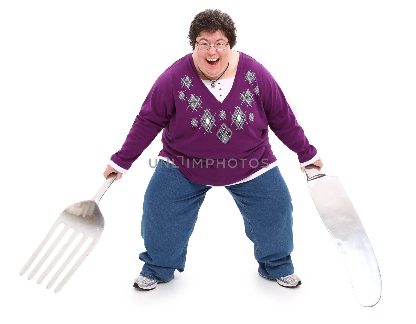Humor image of excited overweight woman with giant fork and knife over white with clipping path.