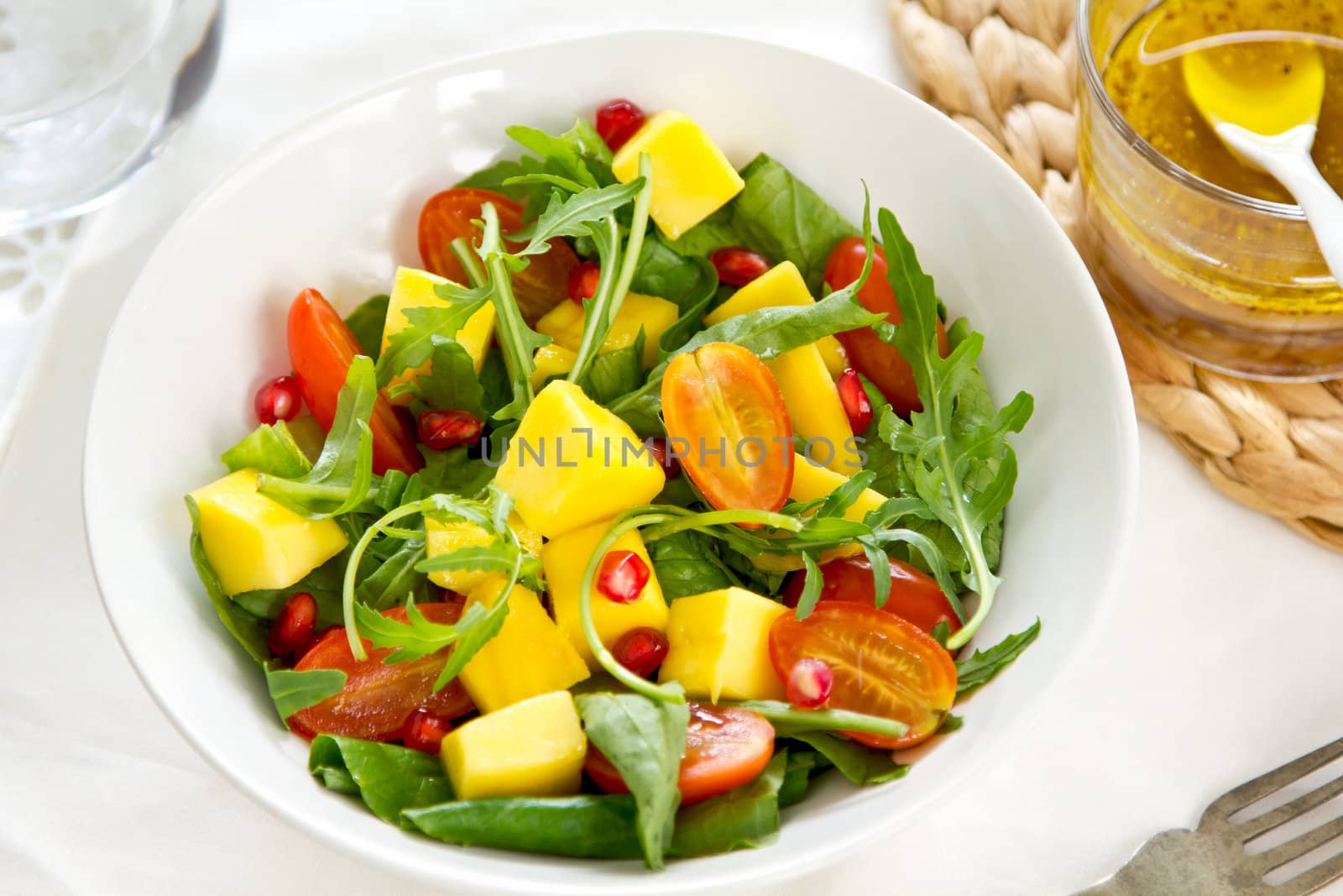 Mango,Pomegranate and cherry tomato with rocket salad in a bowl by vinaigrette