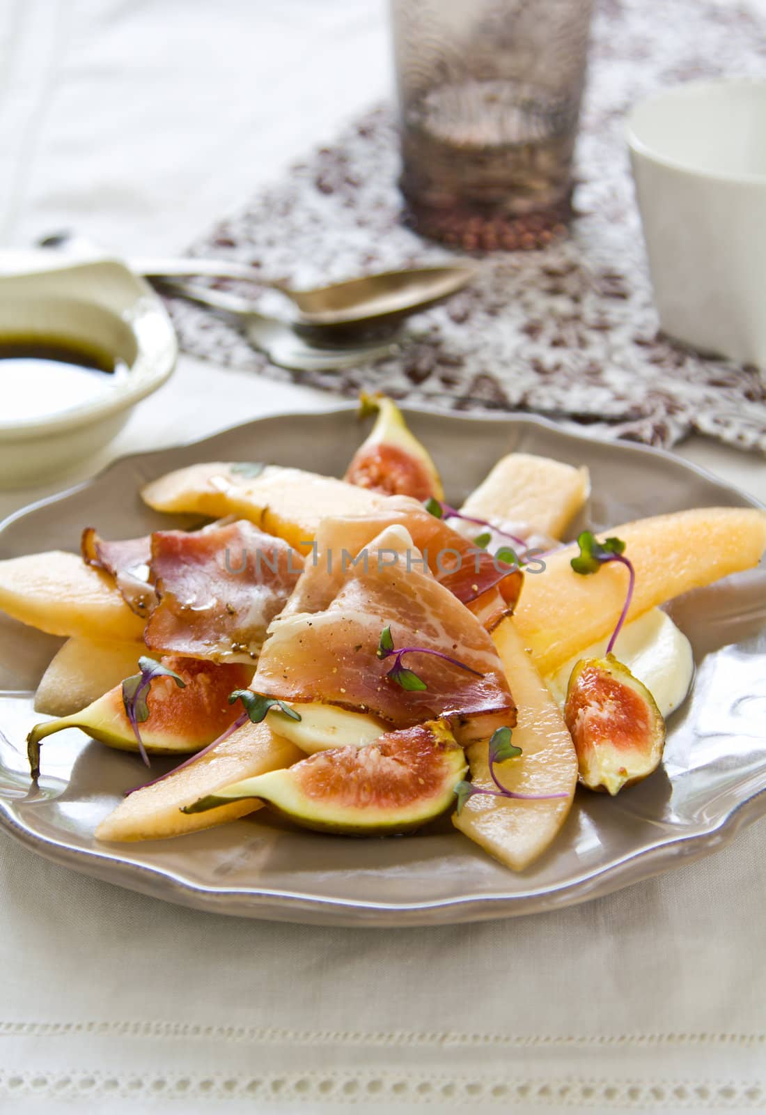 Fig,Cantaloupe with Prosciutto and Mozzarella salad [ Antipasti ] with purple sprout on top by Balsamic dressing