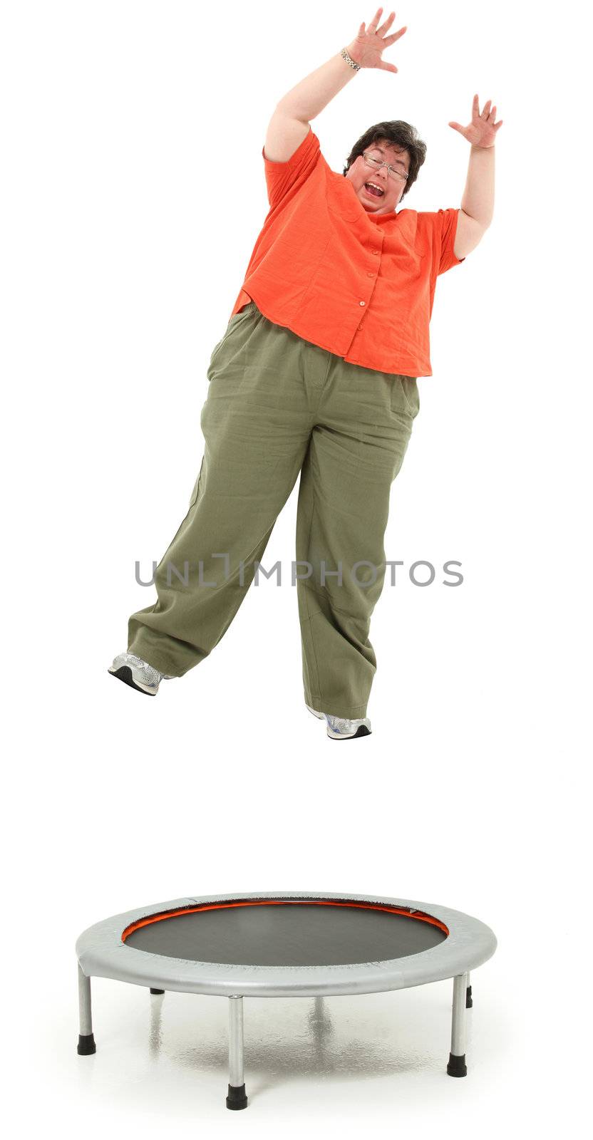 Excited forties obese woman jumping on trampoline over white background.