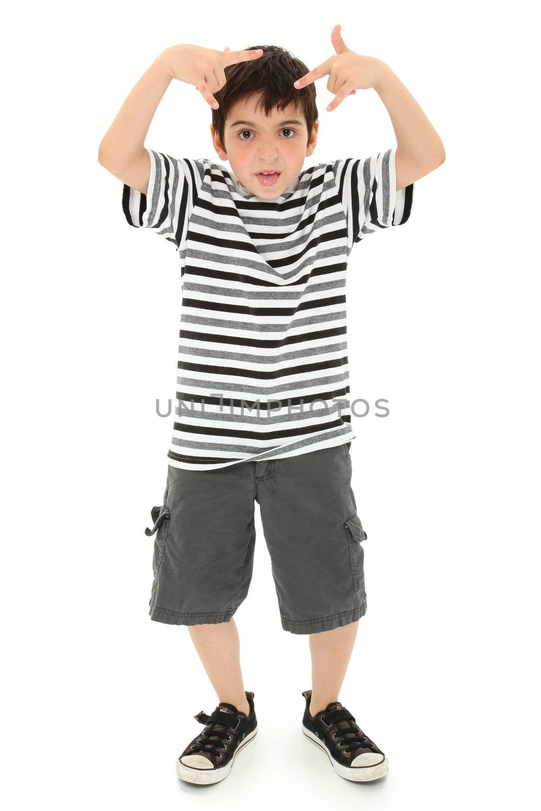 Adorable 8 year old boy making silly faces and gestures over white background.