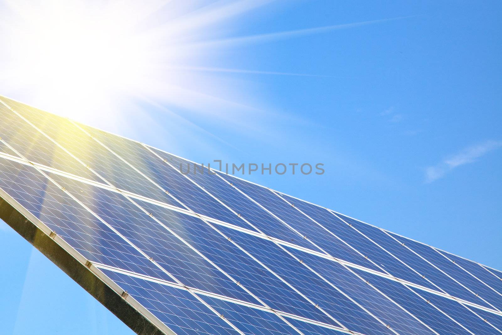 Solar panel against blue sky with sun