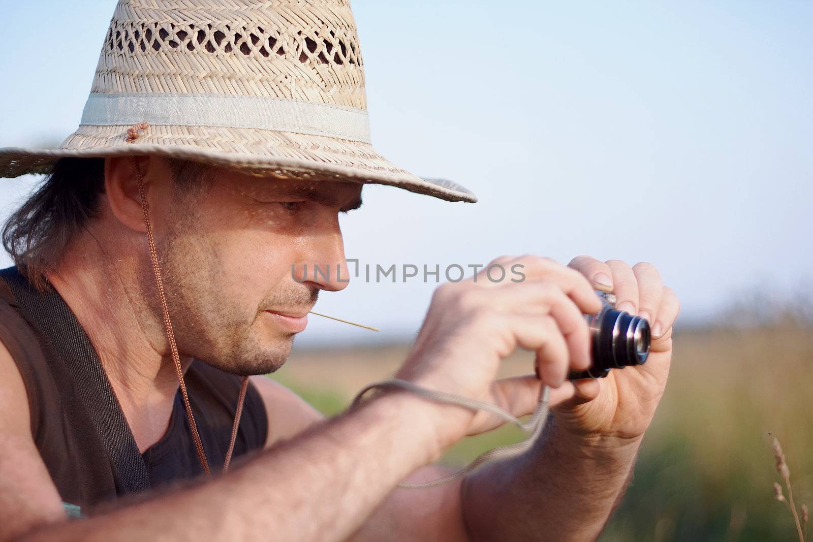 The man in a straw hat with the camera by Azaliya