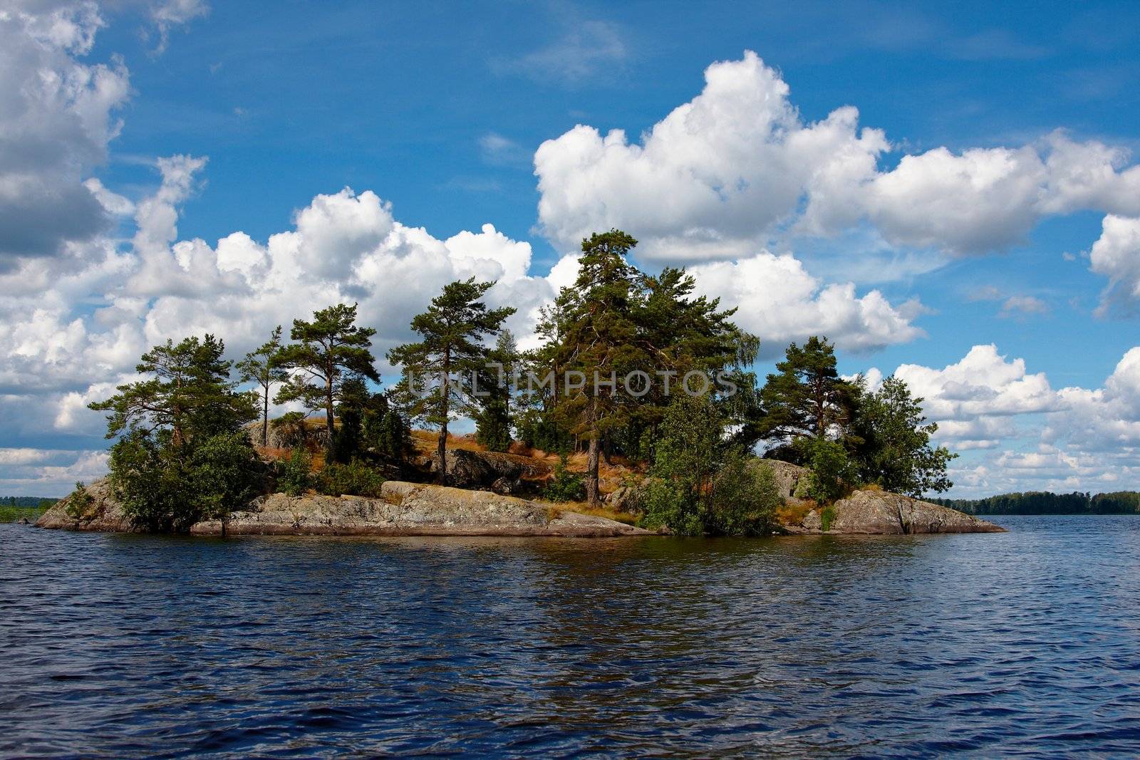 The island on the lake under the dark blue sky with clouds