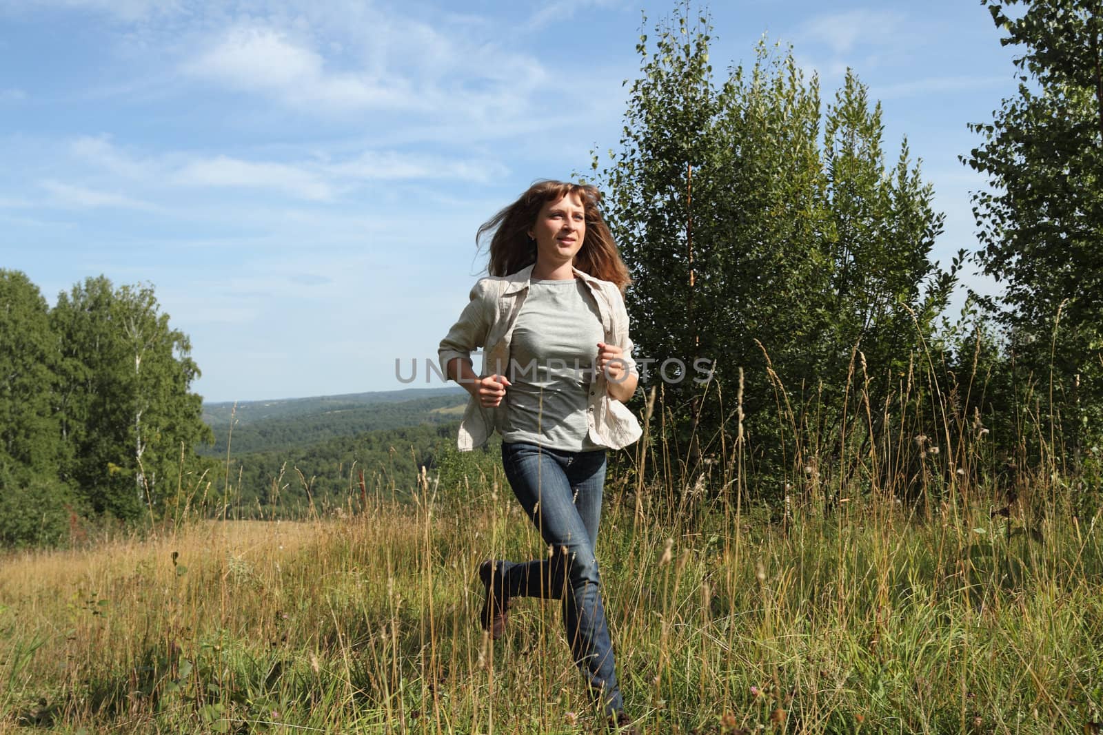 woman runs on the edge of the forest

