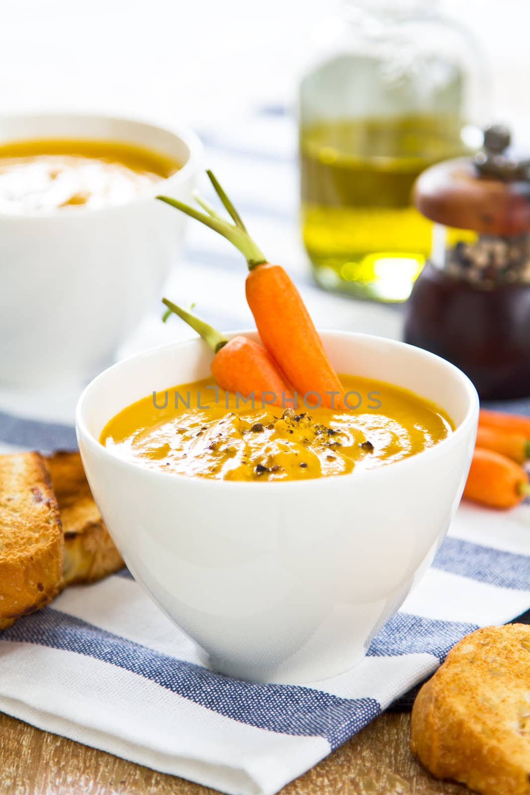 Carrot soup by some toasts and baby carrot