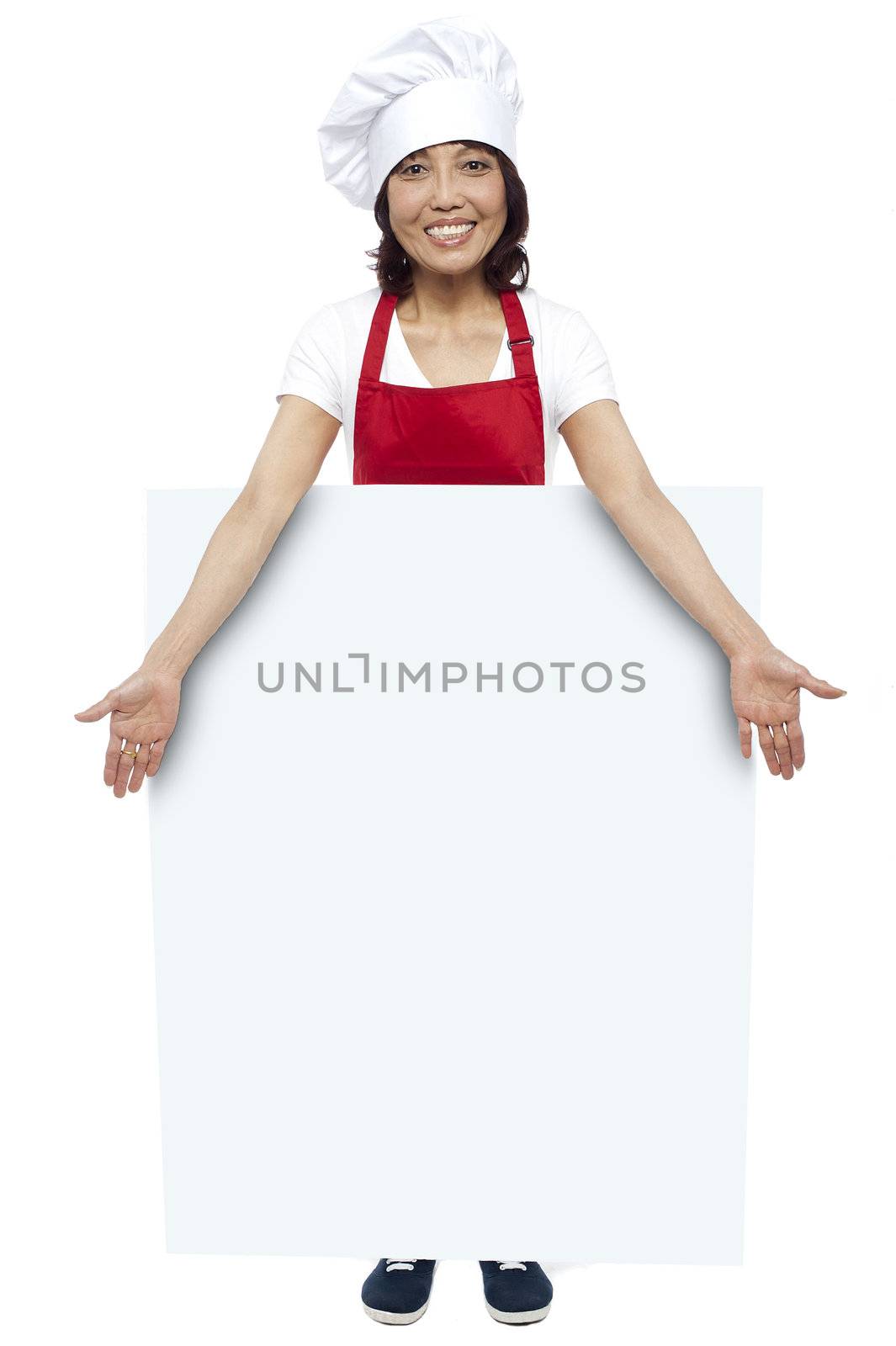Full length portrait of young chef presenting billboard in front of camera