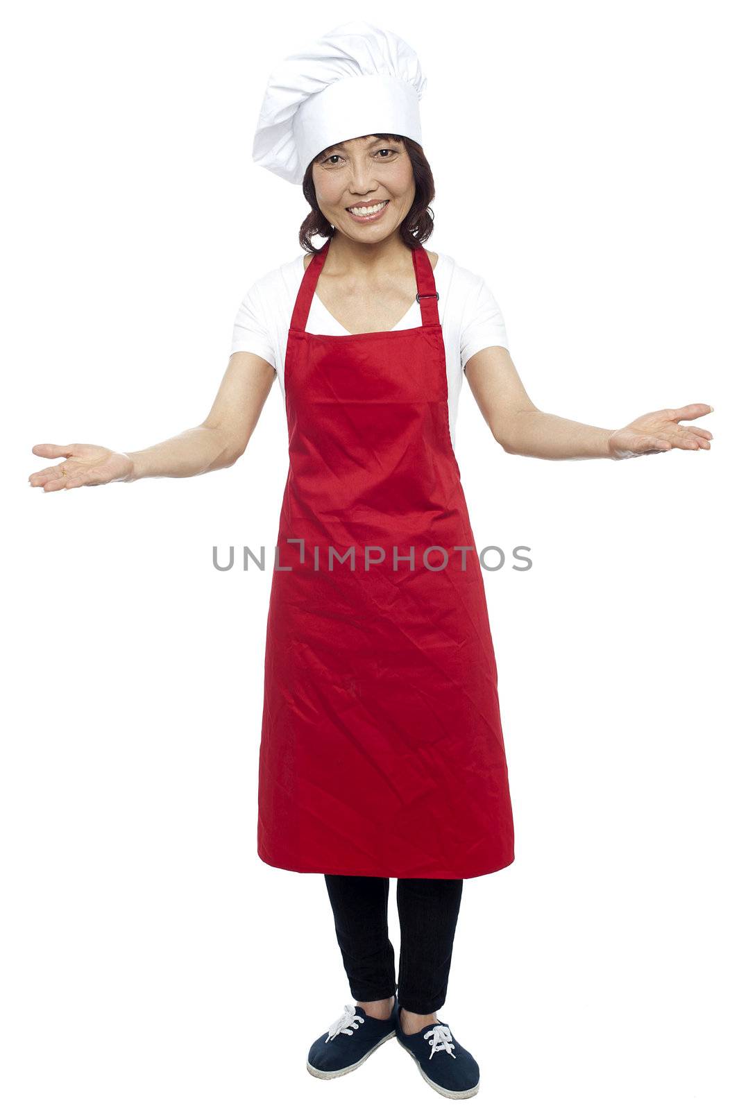 I welcome you my guests. Asian female chef posing with arms wide spread, grand welcome.