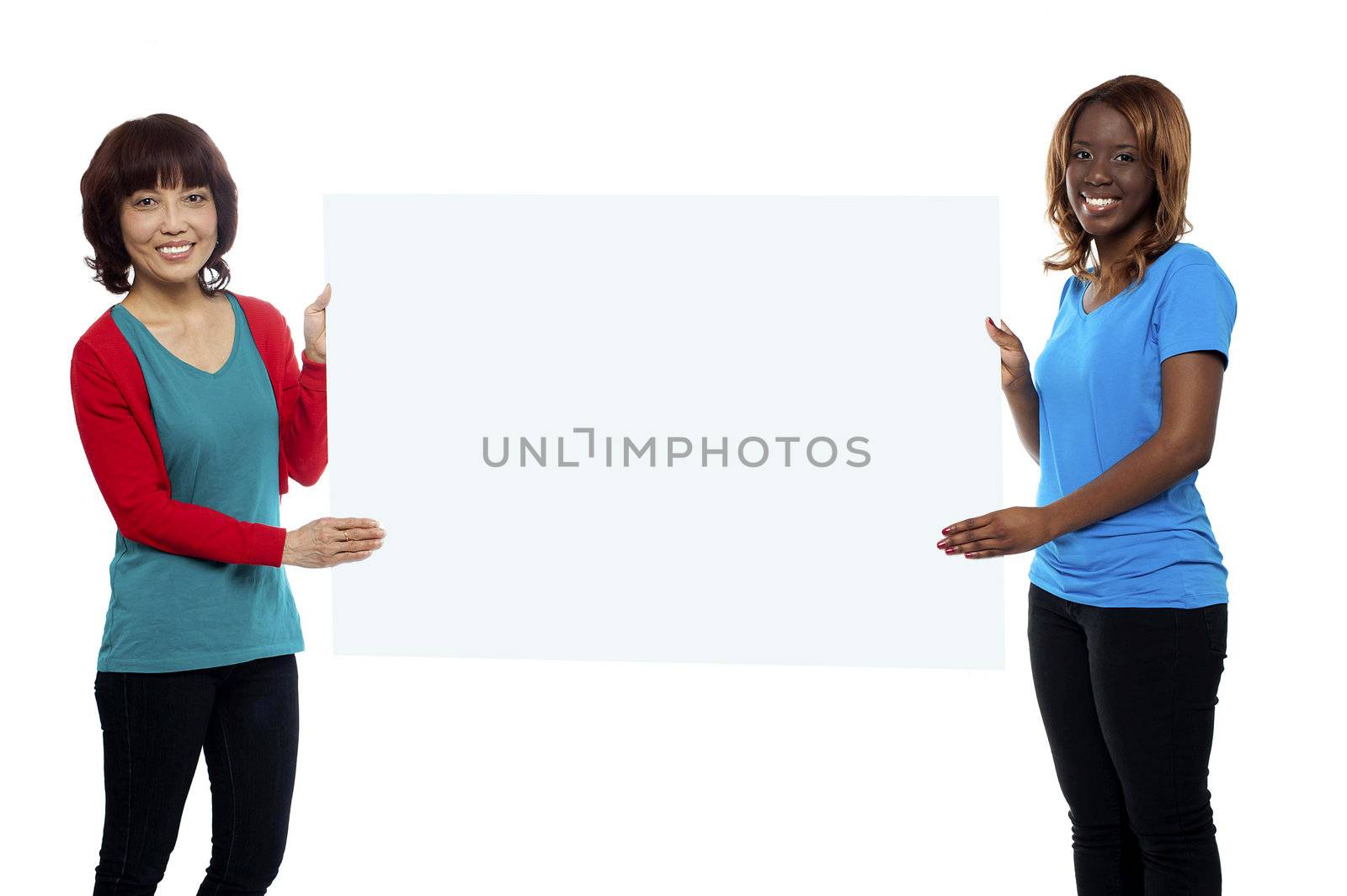 Female marketing executives holding blank billboard in front of camera