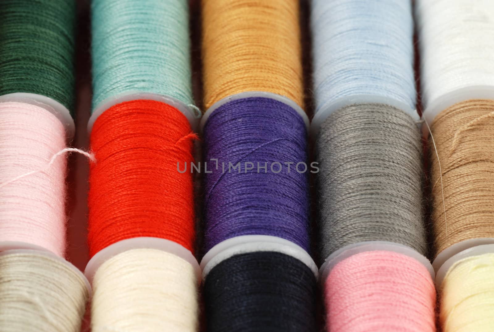 colorful spools of multi colored threads for sewing and knitting