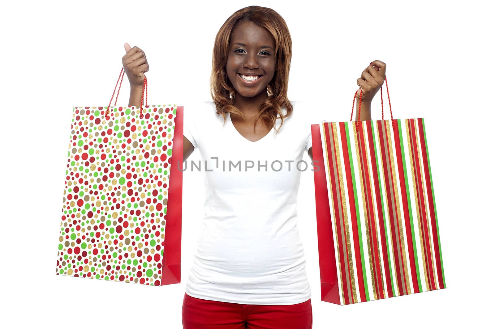 Shopaholic woman carrying shopping bags in both the hands isolated against white