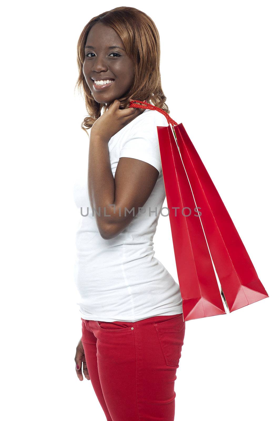 Casual young girl carrying shopping bag isolated over white background