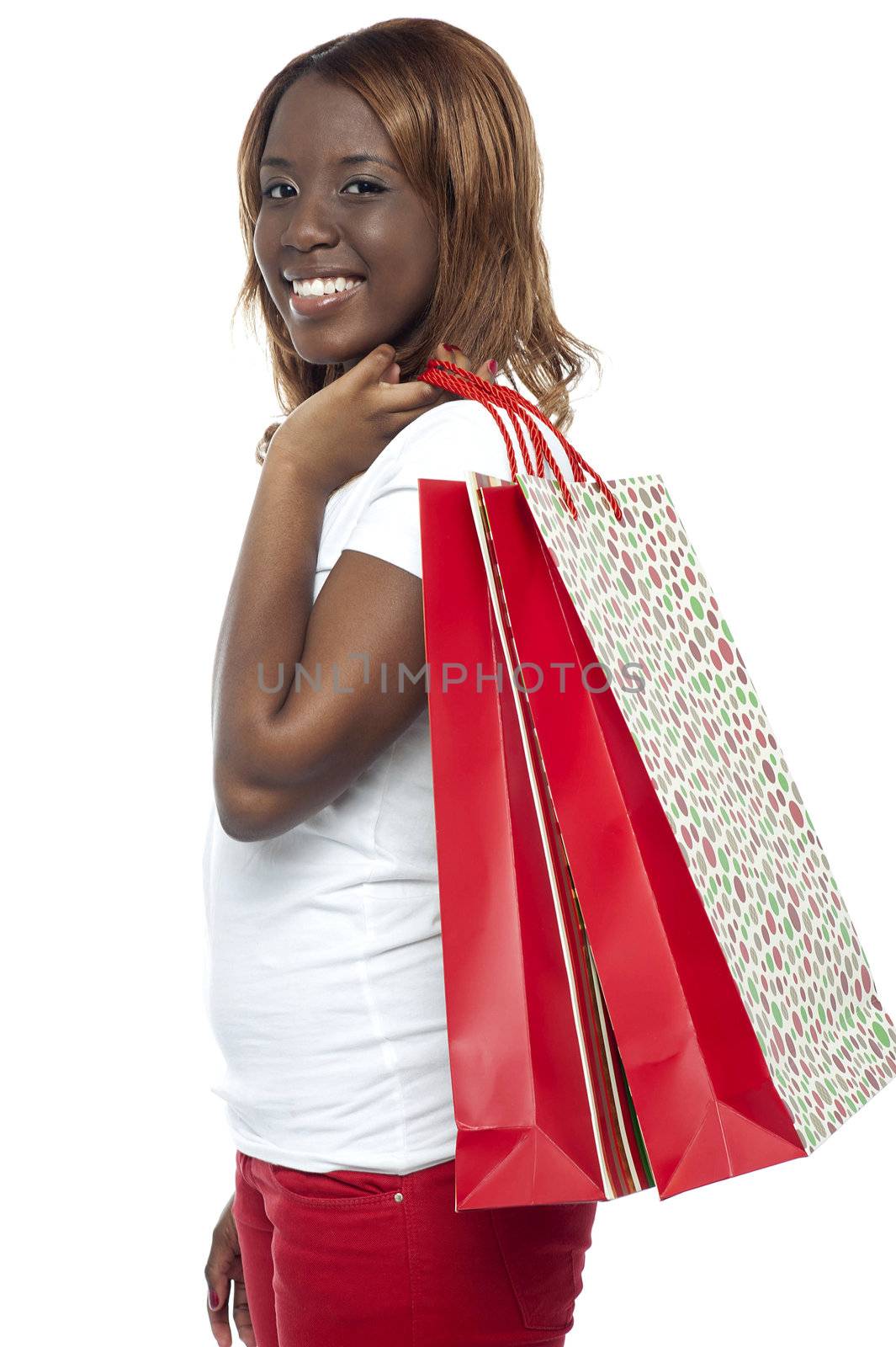 Shopaholic young girl carrying shopping bags over her shoulders