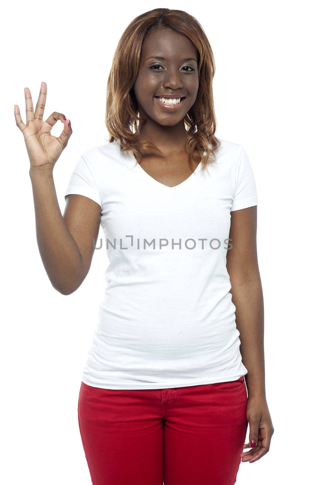 Smiling african young girl gesturing okay sign isolated over white background