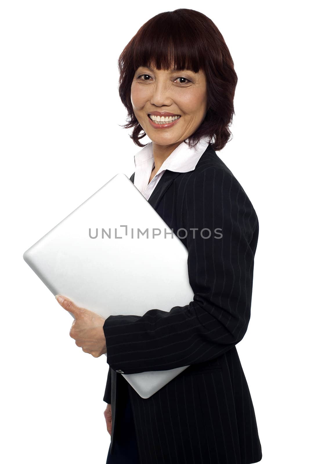 Asian corporate female holding laptop and smiling at camera