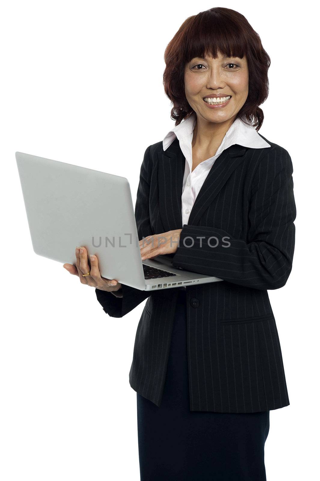 Portrait of a businesswoman working on laptop. Looking at camera and smiling