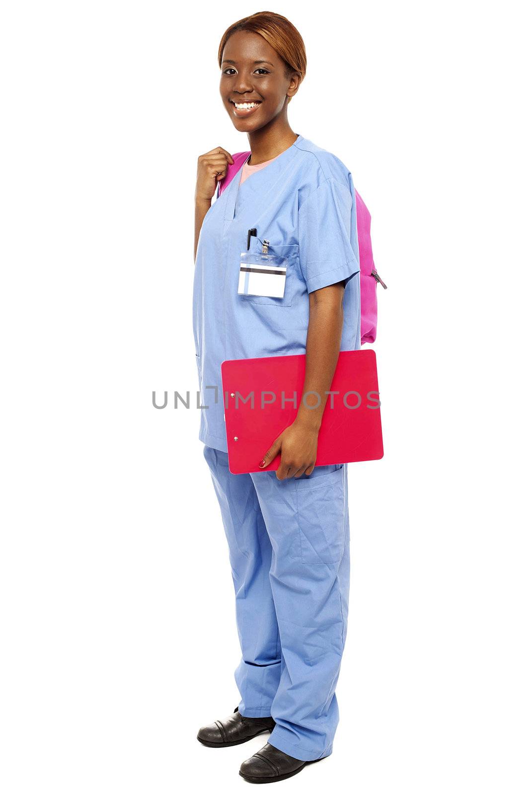Junior female doctor under training. Ready to attend class holding backpack and clipboard